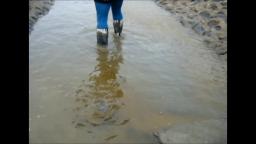 Jana goes in mud flat with zebra rubber boots and washes them in stream trailer