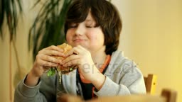 stock-footage-young-boy-eating-hamburger